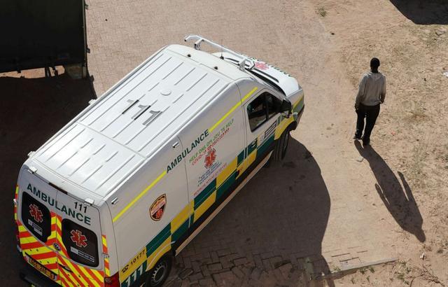 南非开普敦，一辆救护车驶过行人身边。