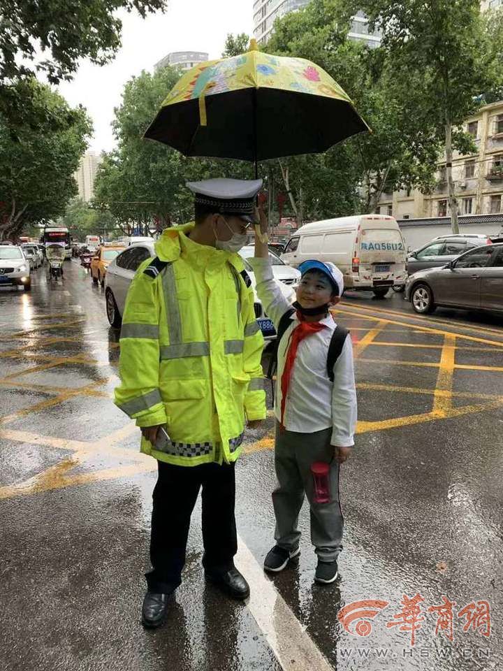 暖心!交警冒雨疏导交通 小学生主动帮忙打伞