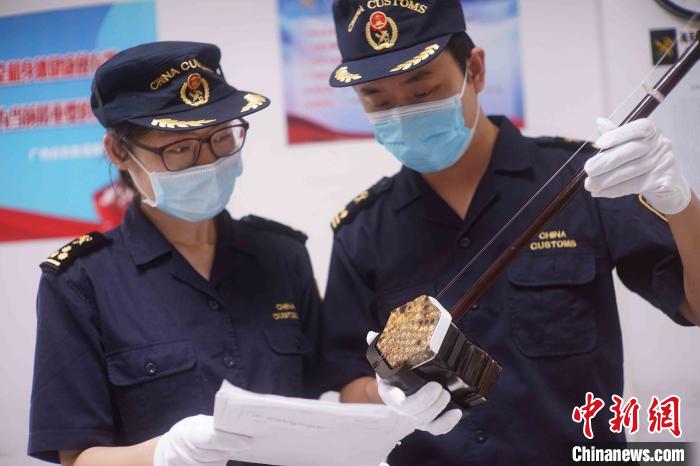 广州白云机场海关关员正在核查蟒蛇制品情况 齐骁翔 摄