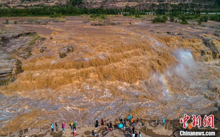 游客在黄河壶口岸边近距离欣赏瀑布的壮观景象。　兰华 摄
