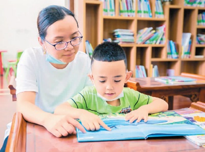 在内蒙古自治区呼和浩特市玉泉区图书馆，小朋友在家长陪伴下读书。 丁根厚 图（人民视觉）