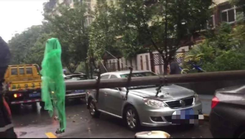 ​西安延康东巷一电杆雨中倒下 砸中路边小轿车无人受伤
