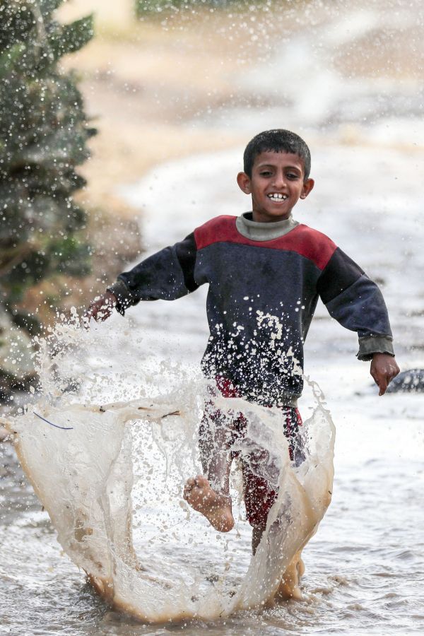 5月19日，加沙地带的汗尤尼斯迎来高温天气，巴勒斯坦男孩在一处水坑中嬉戏。（新华社）