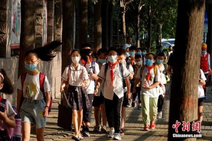 资料图：9月1日，河南郑州，长江东路小学的学生戴口罩有序进入校园。中新社记者 王中举 摄