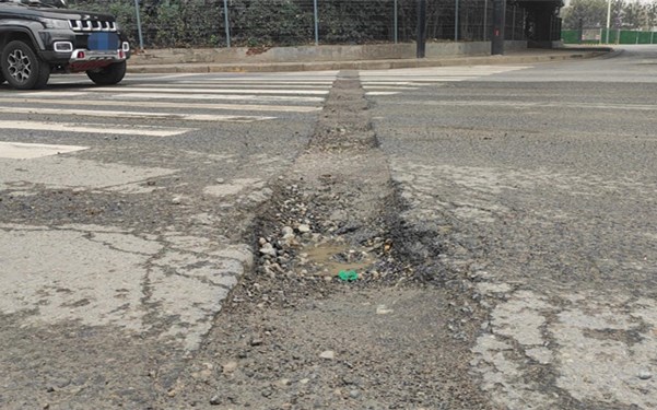 西安南三环上的路坑雨后积水 小轿车通行时不慎导致车胎受损