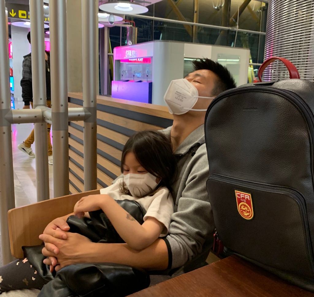 武磊抱着女儿在机场休息。