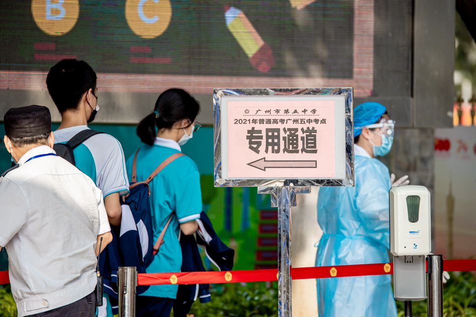 2021年6月7日，广州市第五中学考点，校内工作人员护送中高风险地区学生从专用通道进入考场。