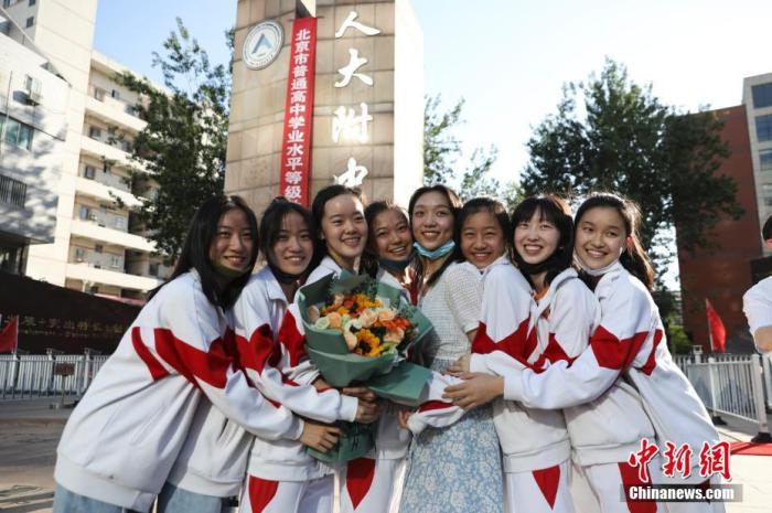 资料图：6月10日，在北京人大附中高考考点外，考生们相拥拍照留念。当日，北京市2021年高考结束。中新社记者 赵隽 摄
