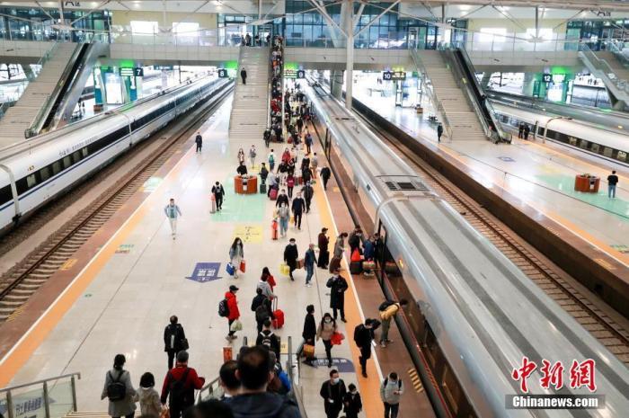 资料图：旅客在武汉火车站站台准备乘坐高铁列车。图片来源：视觉中国