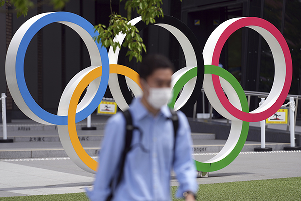 当地时间2021年6月2日，日本东京，男子戴口罩经过奥运五环标识前。人民视觉  资料图