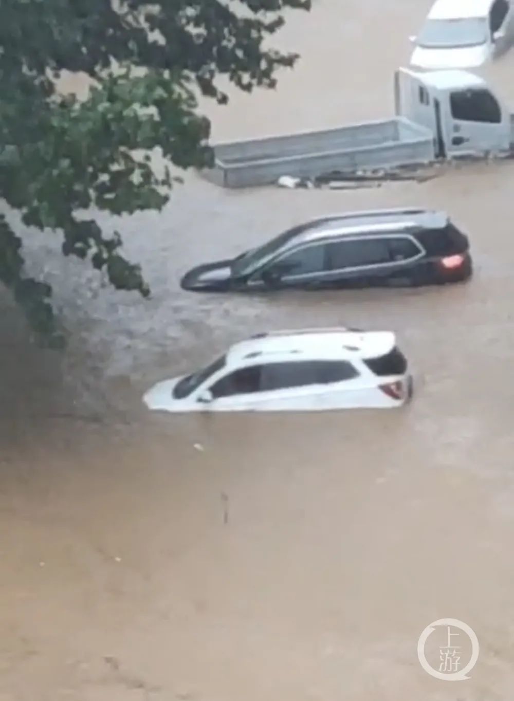 暴雨中，辉县市民李先生眼睁睁看着自家的广告公司和众多车辆被洪水淹没。/受访者供图