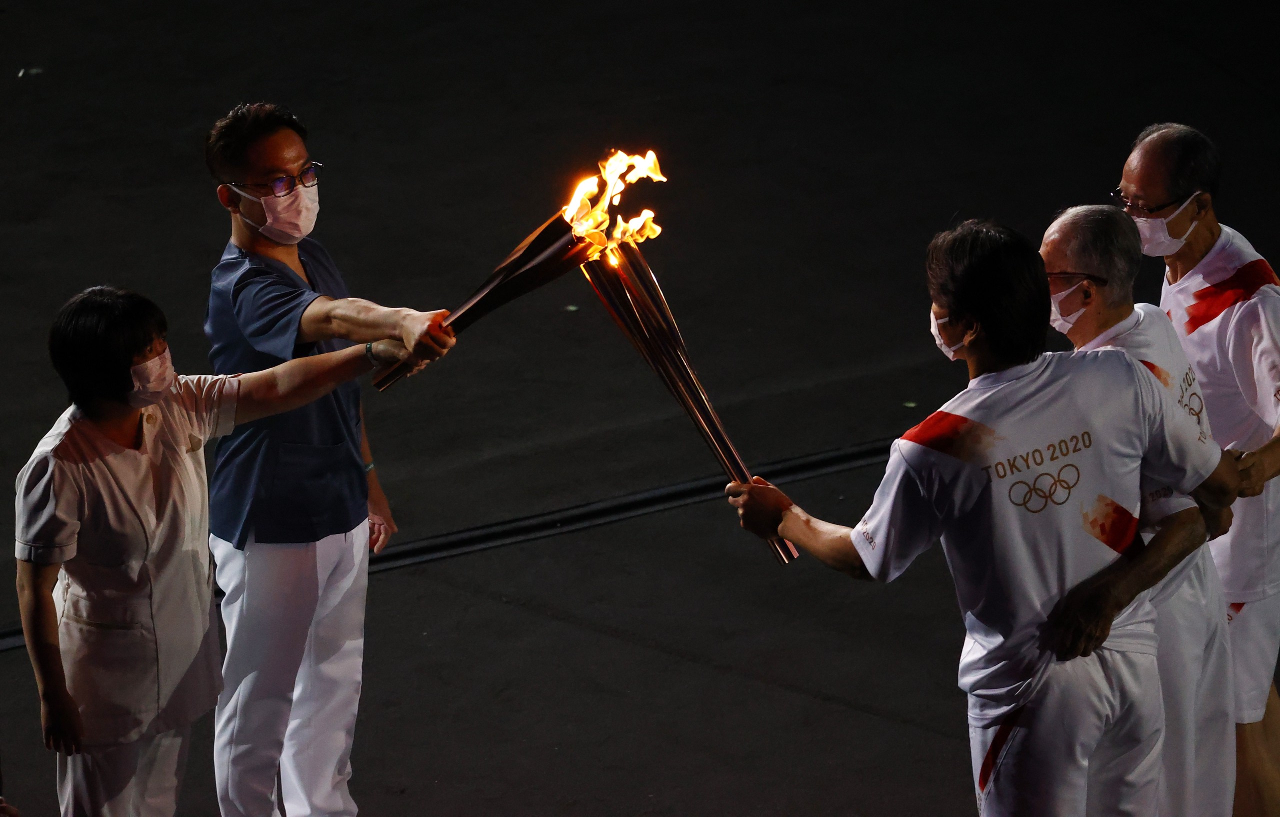 当地时间2021年7月23日，日本东京，2020东京奥运会开幕式。第二棒火炬手是三位著名棒；球运动员，一位是长岛茂雄，另外两位是王贞治和松井秀喜；第三棒火炬手是一位医生和一名护士。