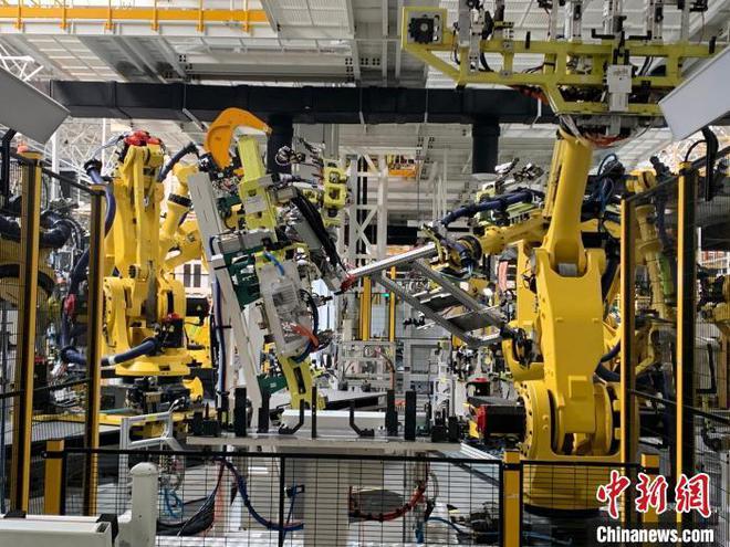 资料图：江西上饶一家新能源电动汽车公司的智慧工厂内，机器人正同时作业。　李韵涵 摄