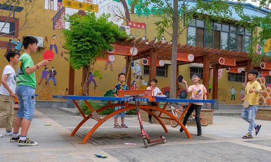 　　孩子们在村里的广场中央打乒乓球