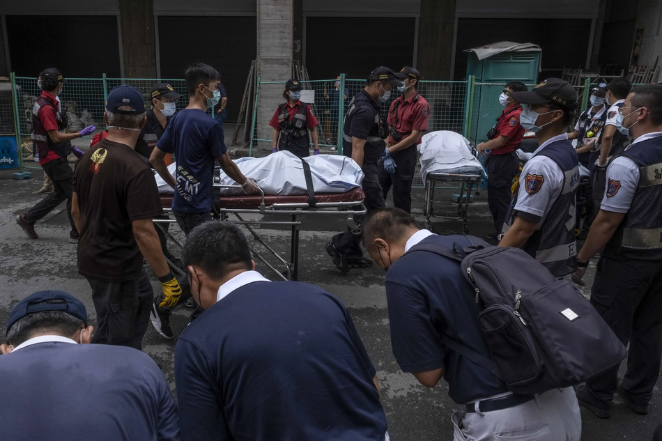 医护人员将遇难者遗体从住宅楼转移出来，市民向遇难者默哀。人民视觉 图