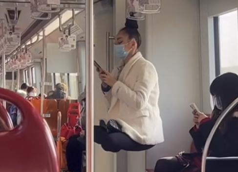 上海地铁“头悬梁”女子：不再在地铁上做类似举动 请别效仿
