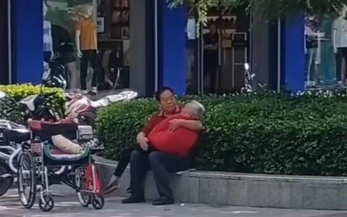 渭南街头男子路边怀抱老人轻拍哄睡 目击者：像小时候妈妈抱着我们