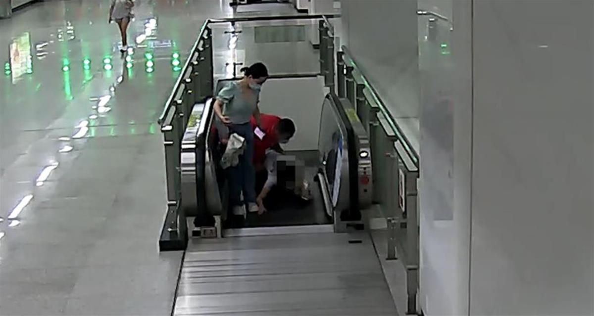 武汉女乘客在电梯上突然栽倒 身后红衣乘客一把抱起