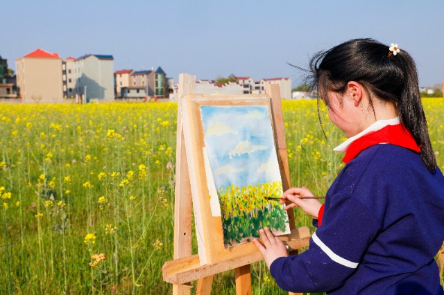 3月15日，江西省吉安市吉州区樟山中心小学的学生在油菜花田间写生画画，描绘春天的美景。 (1).jpg