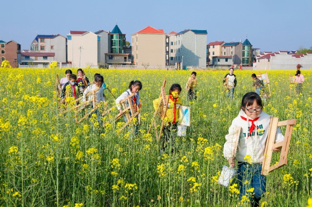 3月15日，江西省吉安市吉州区樟山中心小学的学生在油菜花田间写生画画，描绘春天的美景。 (2).jpg