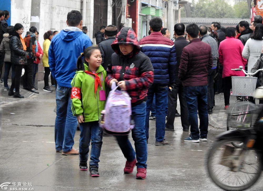 实拍家长阴雨天接放学孩子回家