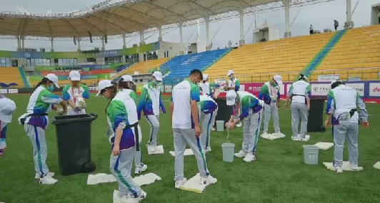 十四运会温暖花絮 垒球项目志愿者用海绵吸干场地积水