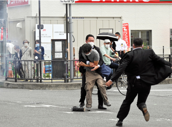 7月8日，日本奈良市，奈良县警方试图捕捉一名疑似向安倍晋三开枪的男子（右）。