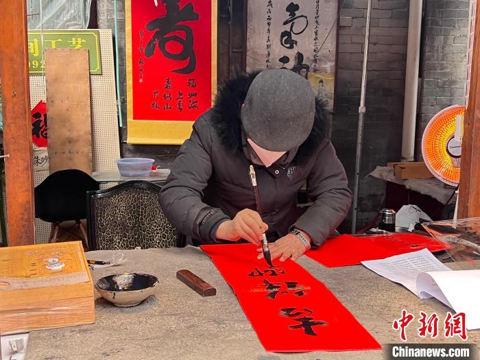图为正在书写春联。　李一璠 摄