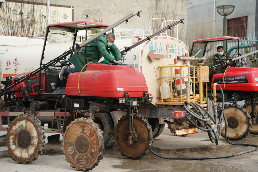 在西安市长安区引镇街道天王村，长安区长丰农机专业合作社的工作人员进行除草作业前的准备工作（2月28日摄）。