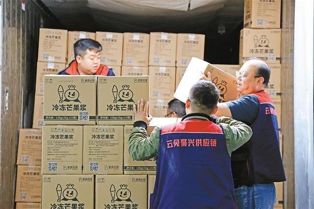 工作人员从冷藏车上卸下货品 记者 谢伟 摄